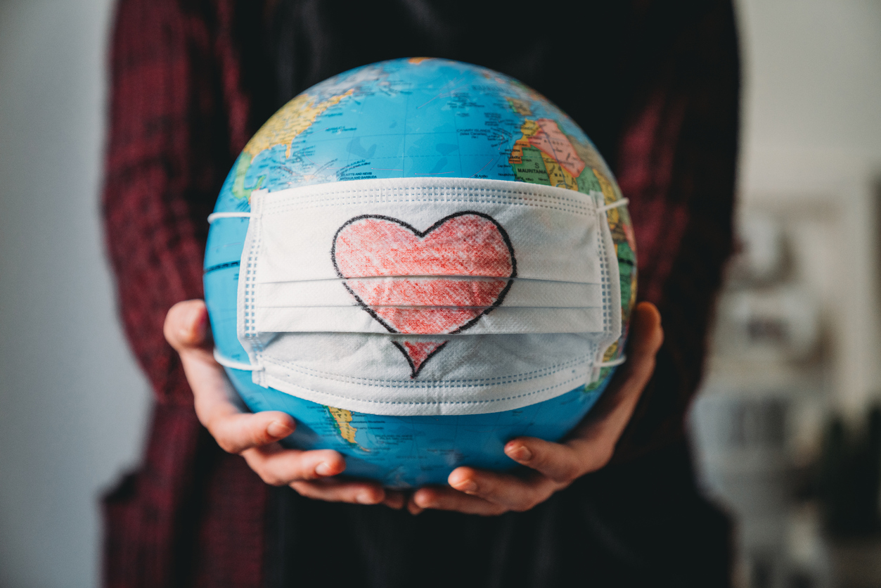 Girl holding globe with heart on it.